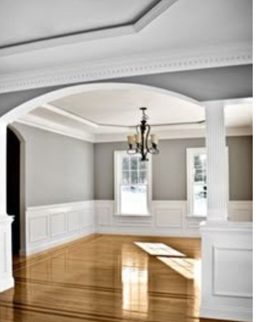 Freshly painted dining room with gray walls, white wainscoting and crown molding