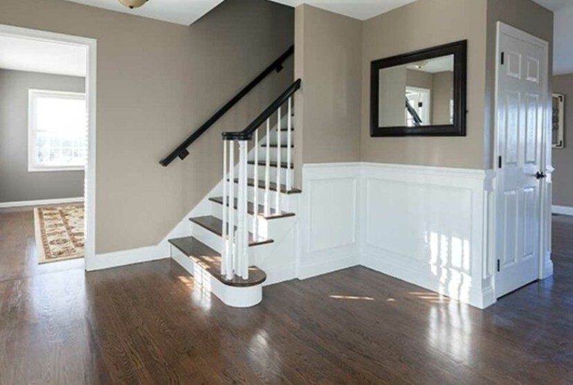 Entry stairway with taupe walls and crisp white wainscoting and trim